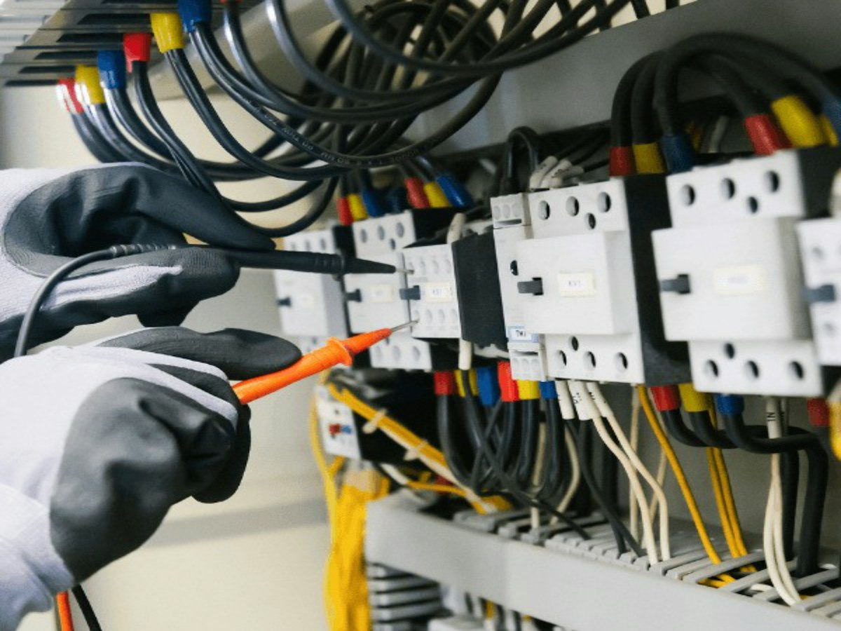 Elektriker prüft einen Schaltschrank mit dem Messgerät