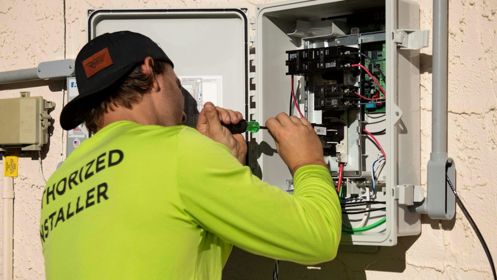 Elektriker arbeitet am geöffneten Zählerkasten