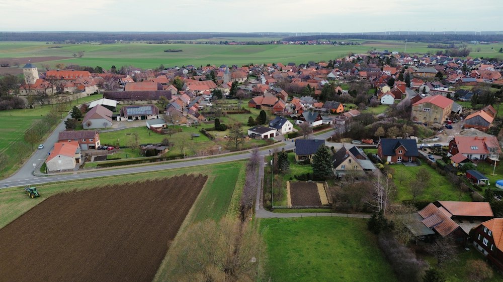 Luftbild eines Dorfes zwischen Feldern